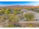 Aerial view of a private backyard oasis with desert landscaping and an outdoor fireplace and lounge area at 37170 N Greythorn Cir, Carefree, AZ 85377