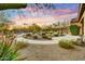 Desert home backyard featuring stone walkways, an outdoor living area, complemented by desert landscaping and distant mountain views at 37170 N Greythorn Cir, Carefree, AZ 85377