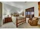 Bedroom showcasing a wrought iron bed frame, bedside tables, a window, and a leather chair at 37170 N Greythorn Cir, Carefree, AZ 85377