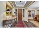 Inviting entryway with an ornate console table, stylish decor, and a view of the dining room at 37170 N Greythorn Cir, Carefree, AZ 85377