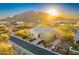 Charming home with a tile roof and desert landscaping set against a backdrop of mountains at sunrise at 37170 N Greythorn Cir, Carefree, AZ 85377