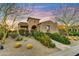 Inviting home exterior with desert landscaping, a stone walkway, and an arched entryway leading to the front door at 37170 N Greythorn Cir, Carefree, AZ 85377