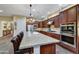 Open kitchen with dark wood cabinets, stainless appliances, tile backsplash and an island with seating at 37170 N Greythorn Cir, Carefree, AZ 85377