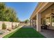 Expansive backyard featuring a covered patio, lush lawn, desert landscaping, and a view of the surrounding area at 3822 E Tracker Trl, Phoenix, AZ 85050