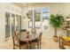 Bright breakfast nook with round glass table, four chairs, stylish lighting, and plantation shutters at 3822 E Tracker Trl, Phoenix, AZ 85050