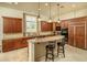 Gourmet kitchen with custom wood cabinetry, granite countertops, and a spacious center island with seating at 3822 E Tracker Trl, Phoenix, AZ 85050