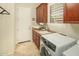 Functional laundry room featuring a washing machine, sink, counter space, and storage cabinets for convenience at 3822 E Tracker Trl, Phoenix, AZ 85050