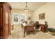 Traditional office with rich wood desk, cabinet, plush rug, and windows with plantation shutters at 3822 E Tracker Trl, Phoenix, AZ 85050