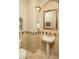 Well-appointed powder room with a pedestal sink, decorative mirror, tiled walls, and a convenient toilet at 3822 E Tracker Trl, Phoenix, AZ 85050