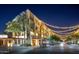Shopping center at night, featuring a restaurant, retail stores, and illuminated lights at 3822 E Tracker Trl, Phoenix, AZ 85050