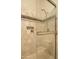 Shower with glass door, tiled walls with a contrasting border, built in toiletry storage, and shower head at 3822 E Tracker Trl, Phoenix, AZ 85050