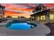 Backyard featuring a pristine pool, desert landscaping, and covered patio area, under a sunset sky at 3861 S Acacia Ct, Chandler, AZ 85248