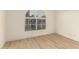 Bedroom with light wood floors, white trim, and a large arched window offering a view at 3861 S Acacia Ct, Chandler, AZ 85248