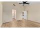 Spacious room with ceiling fan, wood-look floors, bright walls, and a view through an adjacent open door at 3861 S Acacia Ct, Chandler, AZ 85248