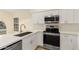 Modern kitchen with sleek white cabinetry, stainless steel appliances, and white countertops at 3861 S Acacia Ct, Chandler, AZ 85248