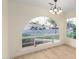 Bright, empty living room featuring a large arched window and modern wood-look flooring at 3861 S Acacia Ct, Chandler, AZ 85248