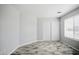 Bright bedroom featuring light gray walls and wood look tile with closet and window at 39894 N Fazio Ln, San Tan Valley, AZ 85140