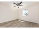 Bright bedroom featuring vinyl floors, white walls and trim, a ceiling fan, and a window with a view to the outdoors at 4027 W Golden Ln, Phoenix, AZ 85051