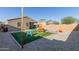 Spacious backyard featuring artificial turf, playground, stone landscaping, and a covered patio for outdoor living and recreation at 40467 W Jenna Ln, Maricopa, AZ 85138