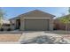Close up front exterior view of single story home with a well maintained yard and neutral color paint at 40467 W Jenna Ln, Maricopa, AZ 85138