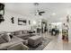 Spacious living room features a comfortable gray sectional, modern decor, and tile flooring at 40467 W Jenna Ln, Maricopa, AZ 85138