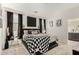 Stylish main bedroom with a modern aesthetic, dark accents, and a checkered blanket at 40467 W Jenna Ln, Maricopa, AZ 85138
