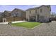 Exterior view of backyard showing turf and a covered patio at 40866 W Sanders Way, Maricopa, AZ 85138