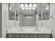 Bathroom featuring double sinks, a large mirror, and a walk-in shower at 40866 W Sanders Way, Maricopa, AZ 85138