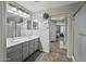 Bathroom featuring double sinks, vanity, large mirror, and walk-in shower at 40866 W Sanders Way, Maricopa, AZ 85138