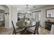 Open-concept kitchen and breakfast nook area, featuring matching gray cabinets and light fixtures at 40866 W Sanders Way, Maricopa, AZ 85138