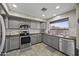 Modern kitchen with gray cabinets, butcher block countertops, and stainless steel appliances at 40866 W Sanders Way, Maricopa, AZ 85138