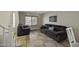 A sunlit living room with tile flooring, plush seating, and a large window at 40866 W Sanders Way, Maricopa, AZ 85138