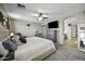 Main bedroom with a large TV, ceiling fan, and ensuite bathroom at 40866 W Sanders Way, Maricopa, AZ 85138