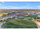 An aerial view shows a golf course and clubhouse with beautiful landscaping and lush green fairways under a blue sky at 4455 E Palmdale Ln, Gilbert, AZ 85298