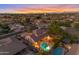 Sunset aerial view of the property showcasing a sparkling pool, covered patio, lush landscaping and neighborhood at 4455 E Palmdale Ln, Gilbert, AZ 85298