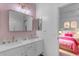 Chic bathroom boasts a double sink vanity, gold accents, and is connected to a pink bedroom, blending style with functionality at 4455 E Palmdale Ln, Gilbert, AZ 85298