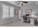 Comfortable bedroom featuring large windows with shutters, a functional desk and ample closet space at 4455 E Palmdale Ln, Gilbert, AZ 85298