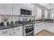 Kitchen features white cabinets, a black countertop, and stainless steel appliances at 4455 E Palmdale Ln, Gilbert, AZ 85298