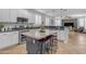 Modern kitchen with white cabinets, a marble-top island with seating, stainless steel appliances, and ample counter space at 4455 E Palmdale Ln, Gilbert, AZ 85298