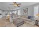 Living room with a neutral sectional couch, a ceiling fan, and an open layout to the kitchen at 4455 E Palmdale Ln, Gilbert, AZ 85298