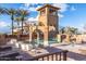 Community pool with water slide and stone tower amenity center, complemented by a relaxing seating area and lush landscaping at 4455 E Palmdale Ln, Gilbert, AZ 85298