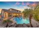 Inviting backyard pool with lush tropical landscaping and a charming waterfall feature at 4455 E Palmdale Ln, Gilbert, AZ 85298