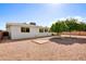 Well-kept backyard features a gravel landscape, mature trees, and a white single-story home with window views at 4734 E Florian Cir, Mesa, AZ 85206