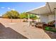 Covered backyard patio with seating, offers a relaxing outdoor space overlooking the gravel and fenced in landscape at 4734 E Florian Cir, Mesa, AZ 85206