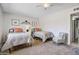 Neutral bedroom featuring two twin beds, carpet flooring, a ceiling fan, and natural light from the entryway at 4734 E Florian Cir, Mesa, AZ 85206