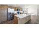 Modern kitchen featuring stainless steel appliances, ample cabinet space, and a large island with a sink at 50426 W Wildwood Rd, Maricopa, AZ 85139