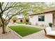 Backyard has desert landscaping, artificial turf, a large shade tree and a brick paver patio at 5448 E Windstone Trl, Cave Creek, AZ 85331