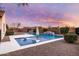 Backyard pool with in-pool lounge chairs, a waterfall feature, and desert landscaping at dusk at 5448 E Windstone Trl, Cave Creek, AZ 85331
