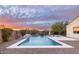 Inviting pool with unique design surrounded by desert landscaping and a dramatic sunset at 5448 E Windstone Trl, Cave Creek, AZ 85331