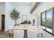 Modern dining area with sleek furniture, ample natural light, and views of the surrounding landscape through large windows at 5455 E Lincoln Dr # 3008, Paradise Valley, AZ 85253